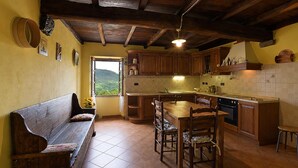 A kitchen with wooden cabinets, a dining table, and a bench.