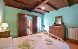 A bedroom with a bed, dresser, and a mirror.