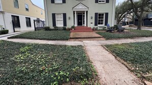 A two-story house with a front porch, a driveway, and a well-maintained lawn. - Heart of Houston five bedroom near everything (Houston)