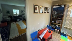 A living room with a sofa, a coffee table, and a bookshelf. - Heart of Houston five bedroom near everything (Houston)