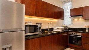 Een moderne keuken met roestvrijstalen apparatuur, houten kastjes, een inbouwoven en een waterdispenser.
