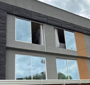 Ein modernes Gebäude mit großen Fenstern und einer Fassade aus Naturstein.