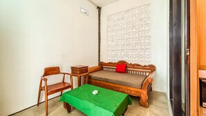 A small room with a wooden bench, a small table, and a green tablecloth.