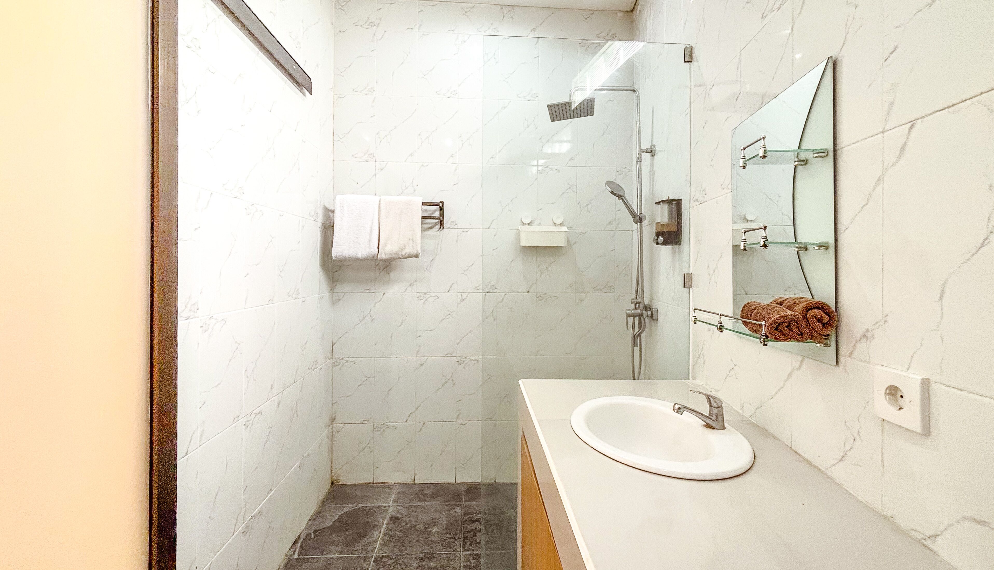 A bathroom with a shower, sink, and mirror.
