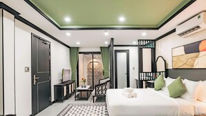 Habitación de hotel con cama, televisor, escritorio y vistas al exterior.