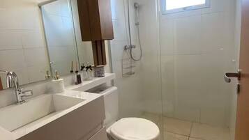 A bathroom with a white sink, mirror, and toilet.