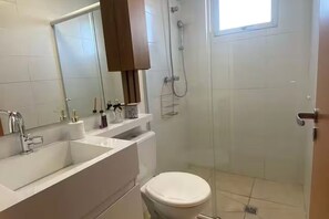 A bathroom with a white sink, mirror, and toilet. - Vrbo Property (Porto Alegre)