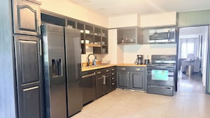 Une cuisine moderne équipée d’un réfrigérateur, d’une cuisinière, d’un four à micro-ondes et d’un évier.