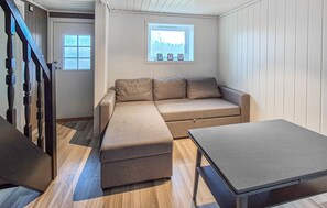 A room with a sofa, a table, a window with a view, and a door. - 2 bedroom nice home in Sletta (Sletta)