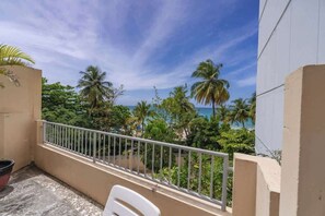 A balcony with a view of palm trees and the sea. - Oceanfront Terrace Apartment - Steps to Beach (Carolina)