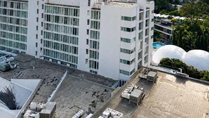 Ein Hochhaus mit mehreren Stockwerken, großen Fenstern und einer flachen Dachterrasse.