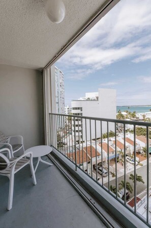 A balcony with a view of a coastal cityscape, including buildings and a beach. - Clean Beach Studio with Balcony in Isla Verde (Carolina)