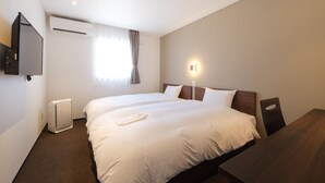 A hotel room with two beds, a TV, an air conditioner, a window with curtains, and a bedside table. - Smile Hotel Kanonji (Kanonji)
