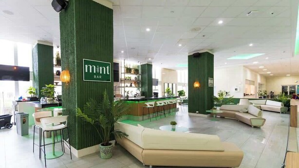 En moderne hotellobby med barområde, siddepladser og en reception.