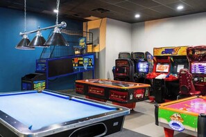 A room with a pool table, arcade games, and a basketball shooting game. - Lux Oceanview Studio w/ 2 QueenBeds • Isla Verde (Carolina)