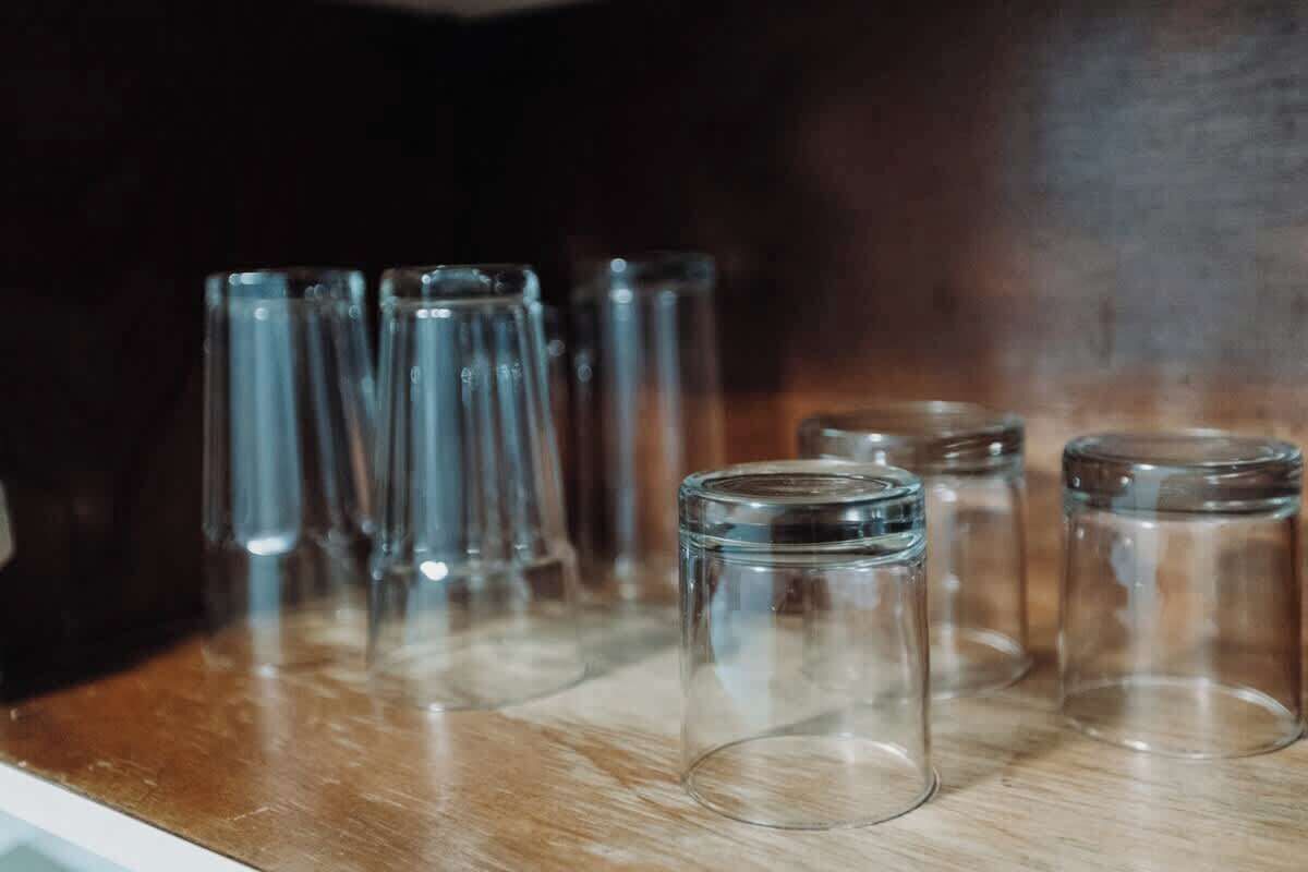 En række klare glasflasker på en træoverflade.
