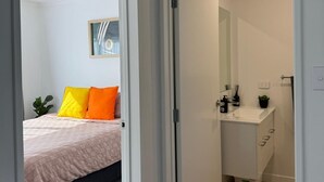 Un dormitorio con cama, mesita de noche y mesilla.