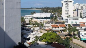Un paisaje urbano costero con edificios modernos, una playa y cielos despejados.