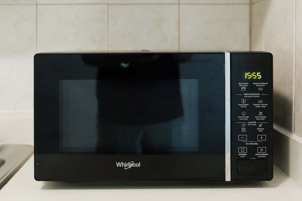 En Whirlpool mikrobølgeovn med digitalt display og kontrolpanel.