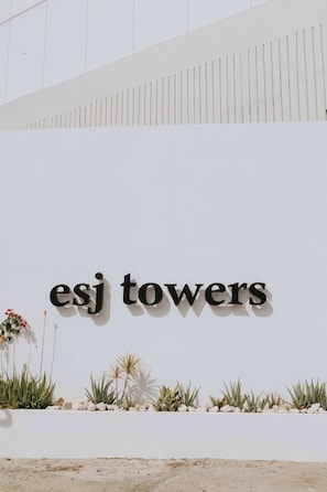 Eine weiße Wand mit dem Schriftzug 'esj towers' in schwarzen Lettern.