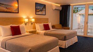A hotel room with two beds, a large window, an air conditioning unit, and a view of the beach. - Beachfront Isla Verde Studio withPrivate Balcony (Carolina)