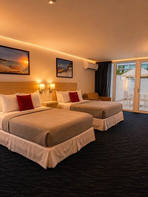 A hotel room with two beds, a large window, an air conditioning unit, and a view of the beach. - Beachfront Isla Verde Studio withPrivate Balcony (Carolina)