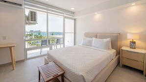 Ein modernes Schlafzimmer mit einem großen Bett, Nachttisch und Blick ins Freie durch ein großes Fenster.