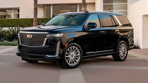 Ein schwarzer SUV vor einem modernen Gebäude mit einer gut einsehbaren Auffahrt.