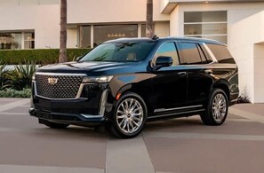 Ein schwarzer SUV vor einem modernen Gebäude mit einer gut einsehbaren Auffahrt.
