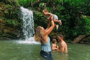 Ein Wasserfall in einer natürlichen Umgebung, Menschen genießen das Wasser.