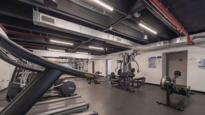 Ett gym med löpband, styrketräningsmaskiner och en roddmaskin.