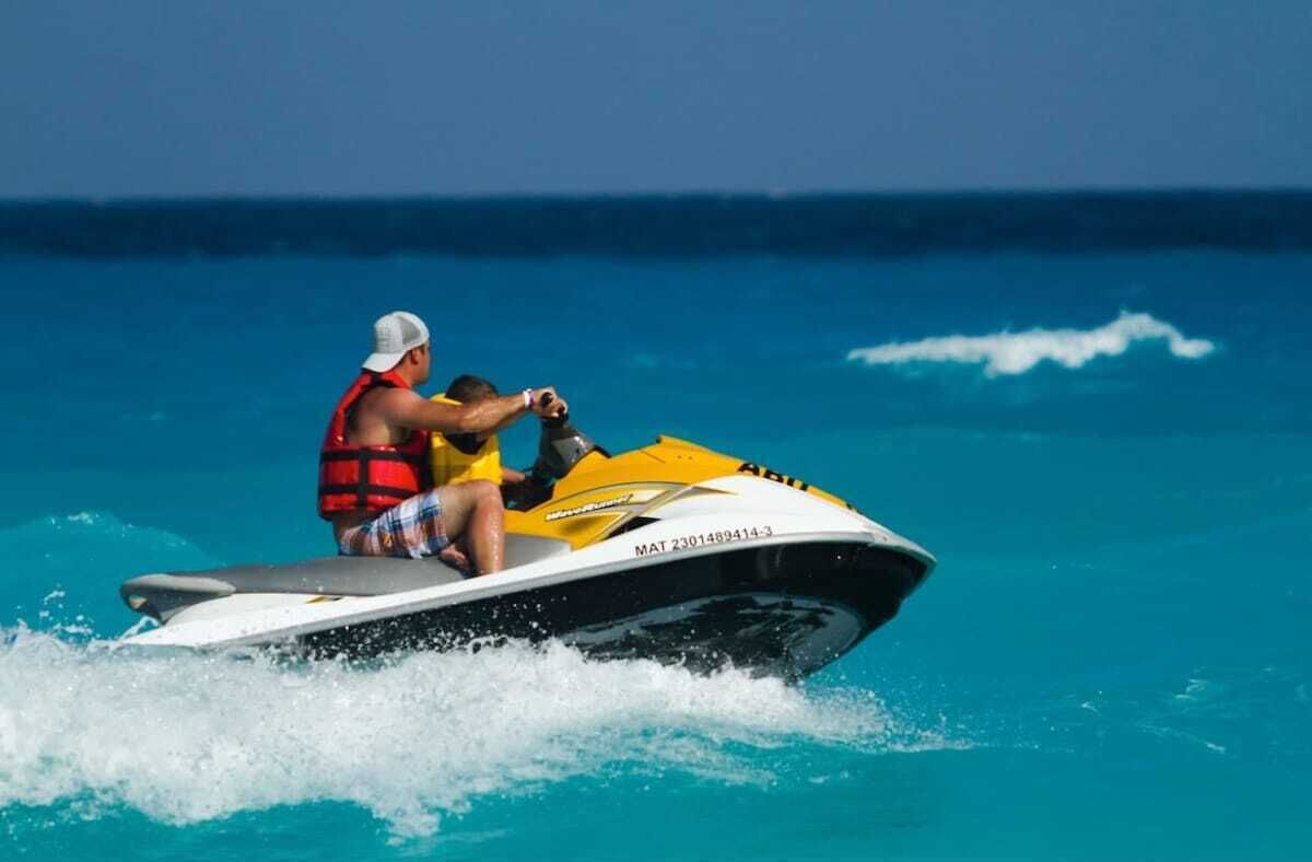 Eine Person fährt mit einem Jetski durch klares, blaues Wasser.