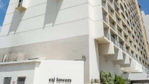 Ein hohes, weißes Gebäude mit dem Schriftzug 'ESJ TOWERS' an der Fassade.