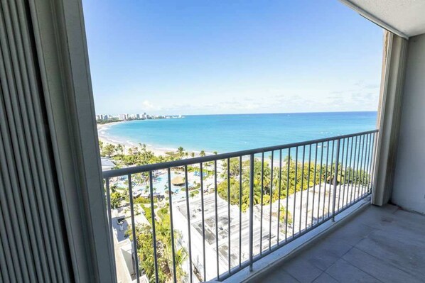 Ein Balkon mit Blick auf Strand und Meer.