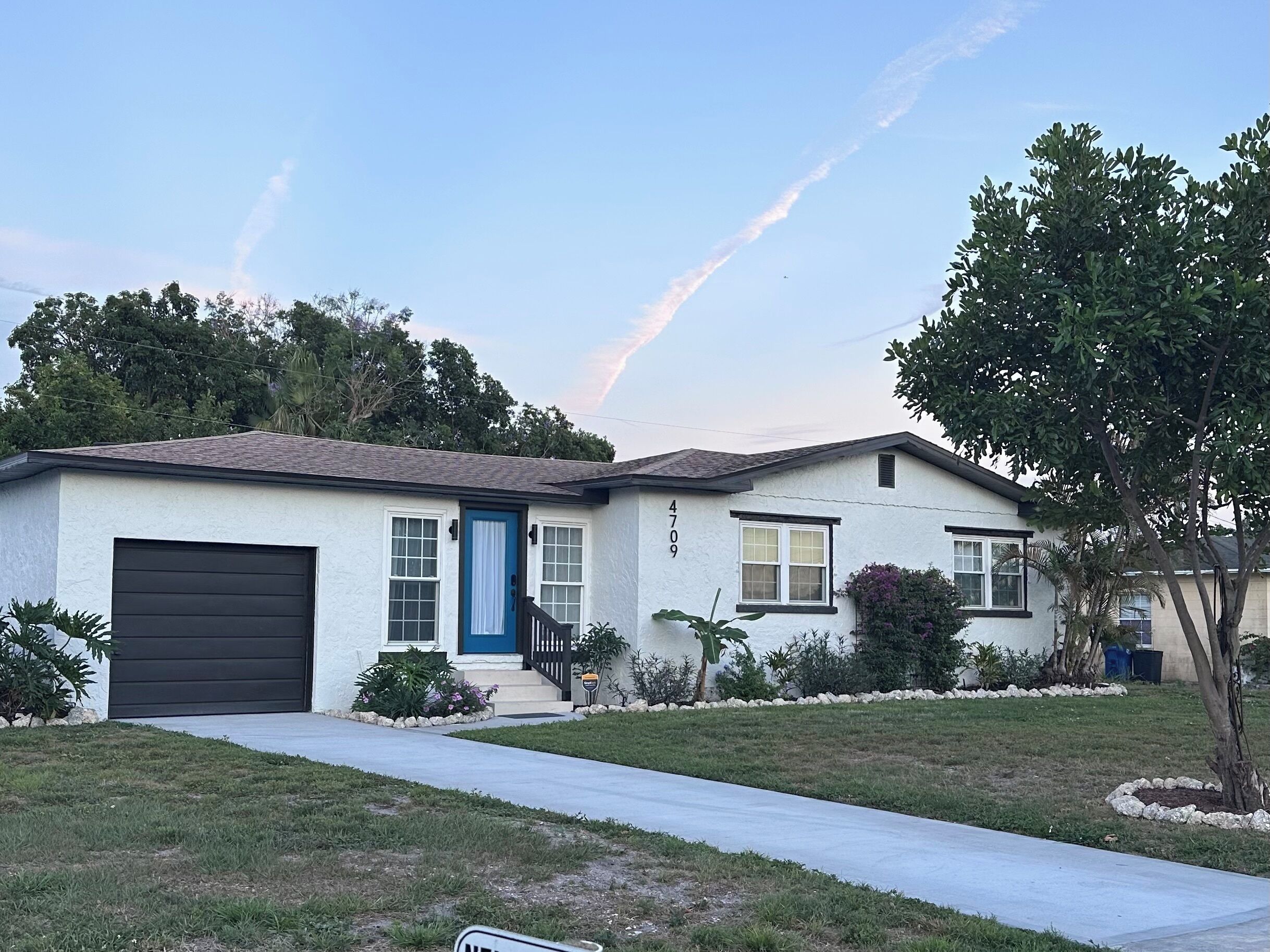 A single-story house with a garage, a front porch, and a well-maintained lawn.