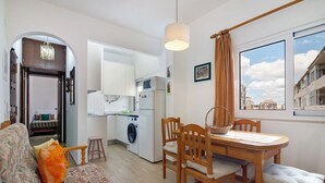 A compact living space with a dining area, kitchen, and a view of the city. - Apartment 'Lili' with Wi-Fi (Armação de Pêra)