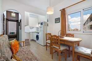 Un espacio habitable compacto con comedor, cocina y vistas a la ciudad.