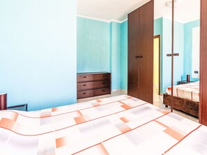 A bedroom with a bed, a dresser, a wardrobe, and a mirror. - La Casa di Tatina by Interhome (Riva Ligure)