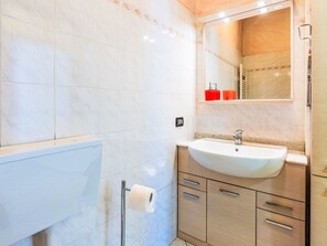 A bathroom with a white sink, mirror, and a towel rack. - La Casa di Tatina by Interhome (Riva Ligure)