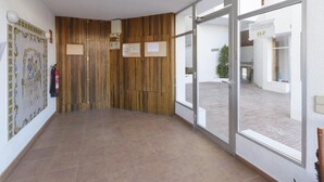 A hallway with wooden paneling, a fire extinguisher, and a tiled floor. - CASA DO BRASIL - Cozy apartment with shared pool and free Wi-Fi (Gandia)