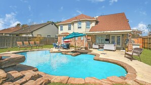 A backyard with a swimming pool, patio furniture, and a barbecue area. - Charming 3-bedroom house with private pool in Houston (Houston)