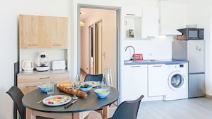 Eine kleine Küche mit Mikrowelle, Toaster und Waschmaschine.