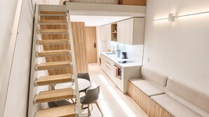 Un interno moderno con una scala, un angolo cottura e una zona relax.