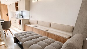 Un soggiorno moderno con un divano, un'area pranzo e una cucina.