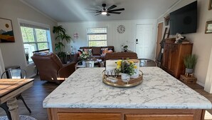 A spacious kitchen with a marble island, wooden cabinets, and pendant lighting. - Stunning Pool House Between Lakewood and Mountain (Mountain)