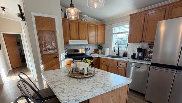 A modern kitchen with wooden cabinets, a marble island, stainless steel appliances, and pendant lighting. - Stunning Pool House Between Lakewood and Mountain (Mountain)