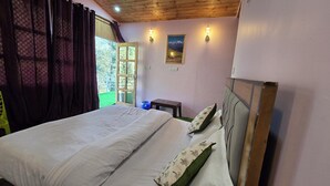 Un dormitorio con cama, ventana con cortinas, una lámpara de pared y un cuadro.