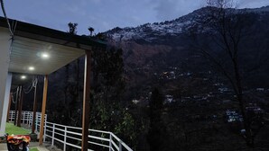 Un balcón con vistas a una montaña nevada y un valle.