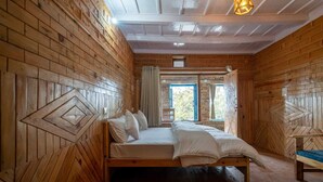 Ein Zimmer aus Holz mit einem Bett, einem Fenster und einer Tür.