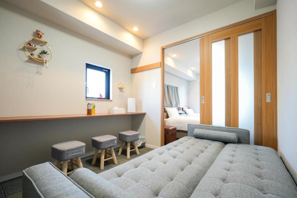 Habitación de hotel con cama, espejo, tocador con artículos de aseo y un pequeño rincón de descanso.